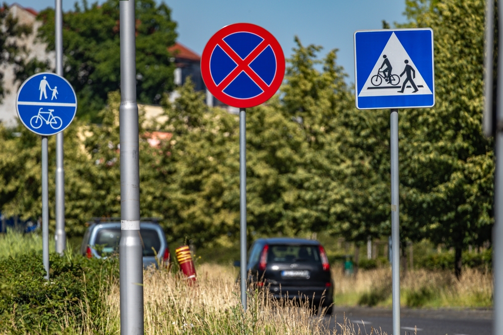 znaki drogowe przy ścieżce rowerowej i przejściu dla pieszych